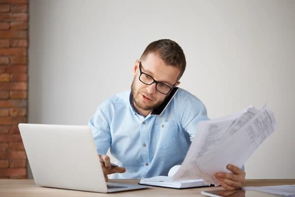 Persona revisando documentos y facturas en su escritorio